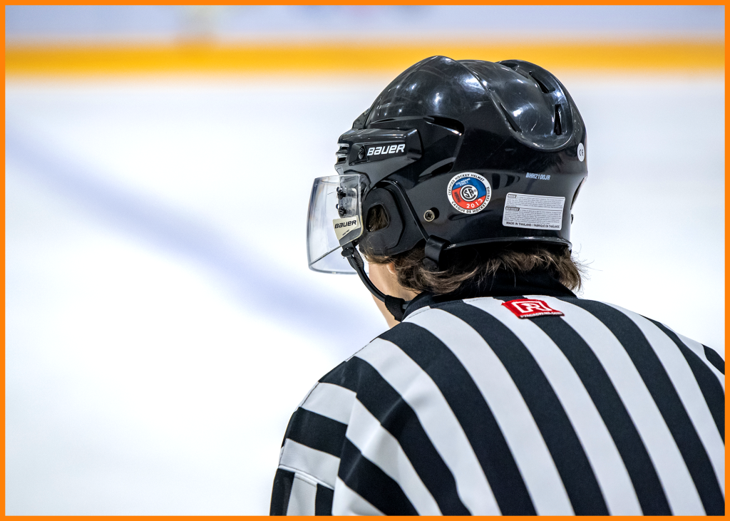 An ice hockey official gets ready for faceoff.